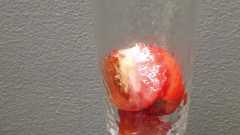 Fresh red tomatoes cut in halves falling into a jar Stock Footage 160259024
