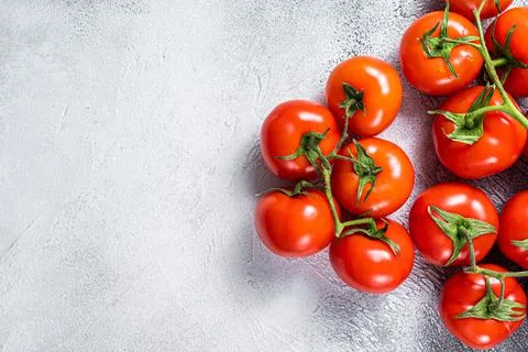 Fresh red tomatoes on kitchen table. White background. Top view. Copy space Stock Photos