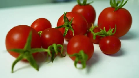 Fresh Red Tomatoes on White Surface, A close-up of fresh red tomatoes with .. Stock Footage 304978784