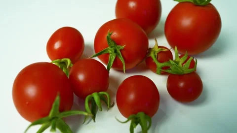 Fresh Red Tomatoes on White Surface, A close-up of fresh red tomatoes with .. Video stock 304978891