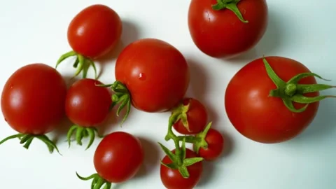 Fresh Red Tomatoes on White Surface, A close-up of fresh red tomatoes with .. 動画素材 304978955