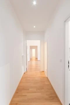 Fresh renovated flat corridor, white walls, wooden floor Stock Photos