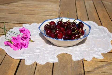 Fresh Ripe Cherries in Sunlight on a Rustic Cottage Garden Table Stock-Fotos