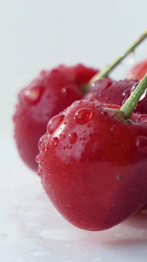 Fresh ripe Cherry close-up. Rotated Organic red cherries isolated on white Stock Footage 230303540