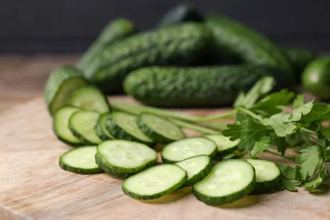 Fresh ripe cucumbers and parsley on wooden table, closeup Stock Photos