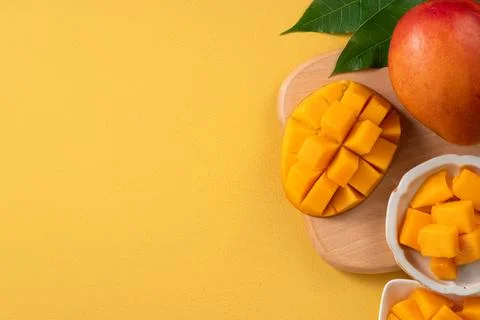 Fresh ripe cut mango fruit slices on yellow background. Stock Photos