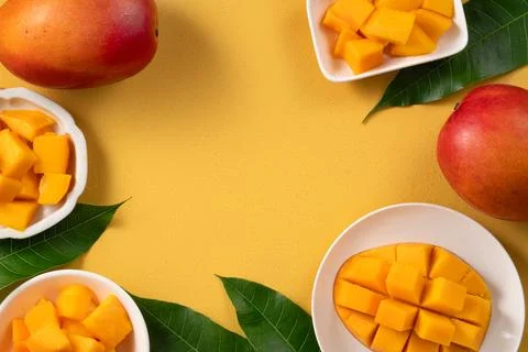 Fresh ripe cut mango fruit slices on yellow background. Stock Photos