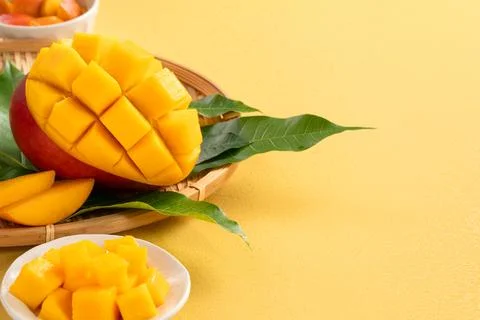 Fresh ripe cut mango fruit slices on yellow background. Stock Photos
