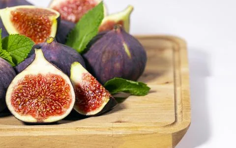 Fresh Ripe Fig with mint leaf on wooden board on white background, Healthy Stock Photos
