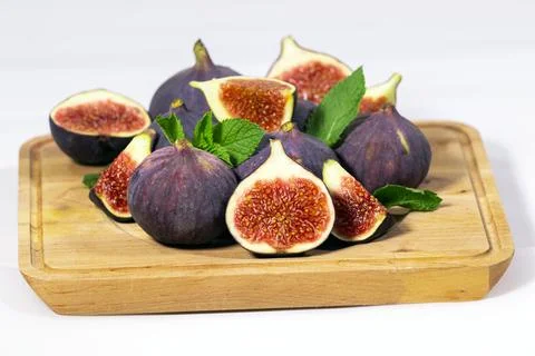 Fresh Ripe Fig with mint leaf on wooden board on white background, Healthy Stock Photos