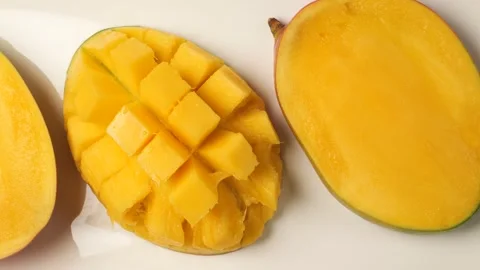Fresh ripe mango fruit cut in half and diced isolated on a white background Stock Footage 344915404