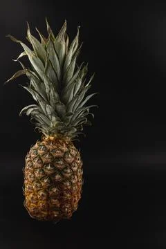 Fresh ripe pineapple on a black background depicting natural beauty Stock Photos