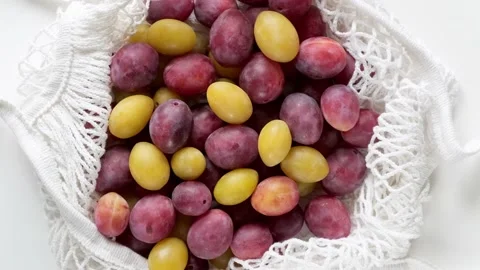 Fresh ripe Plums in a ecological zero-waste net bag placed on white background Stock Footage 220008612