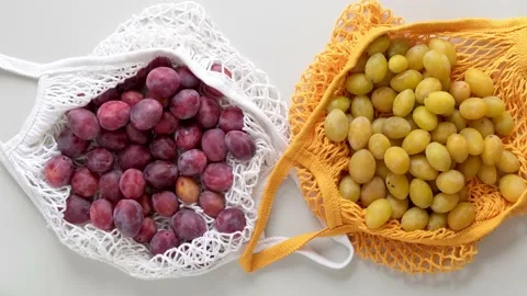 Fresh ripe Plums in a ecological zero-waste net bag placed on white background Stock Footage 220953413