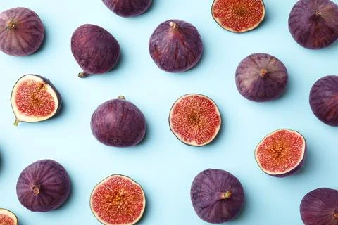 Fresh ripe purple figs on light blue background, flat lay Stock Photos