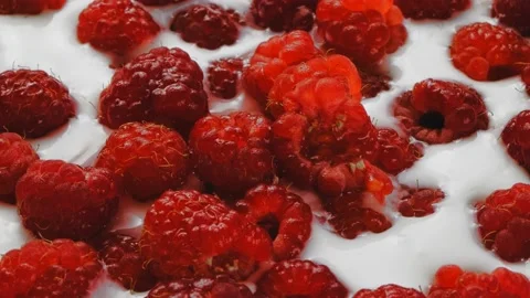 Fresh ripe raspberries float in thick cream spin in a circle 库存影片 203846510