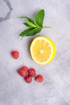 Fresh ripe raspberry fruit with lemon half and mint leaf, summer vitamins Stock Photos