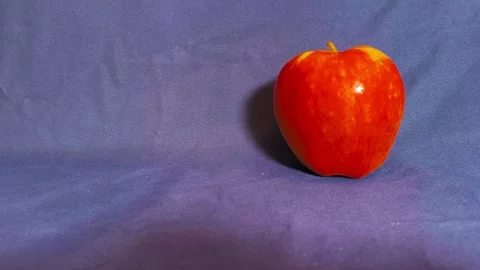 Fresh ripe red rolling apple on dark blue background, organic fruit, health.. 動画素材 318128301