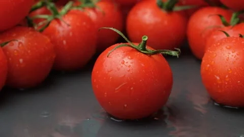 Fresh ripe tomato falling in slow motion, splashing water. Stock Footage 316978065
