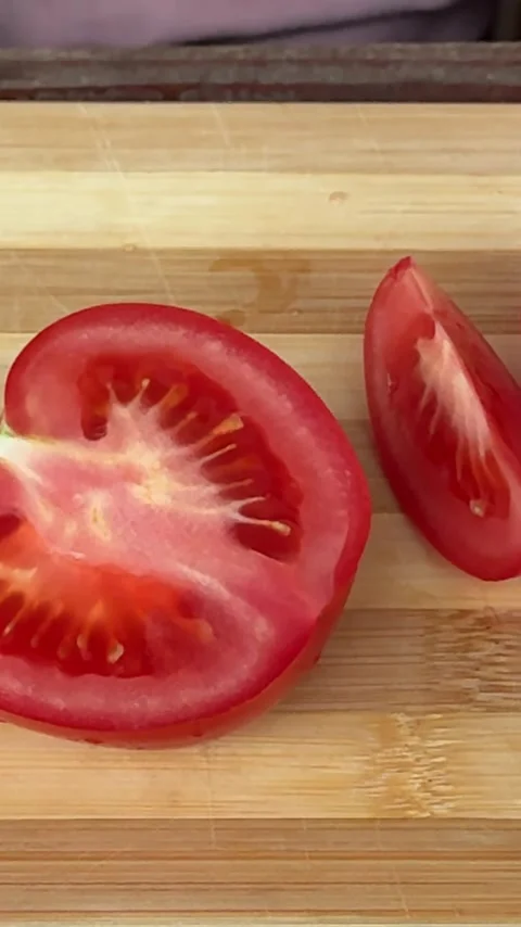 Fresh Ripe Tomato Sliced with Kitchen Knife on Rustic Wooden Cutting Board Stock Footage 345720902