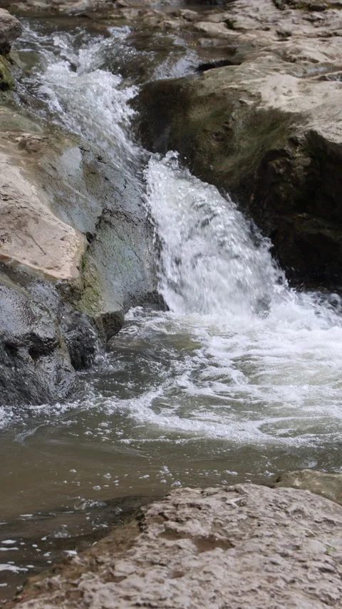 Fresh river water rushing down rocky mountain cascade. Vertical Stock Footage 341886546