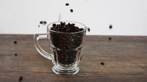 Fresh roasted coffee beans falling in a glass Stock Footage 130400176