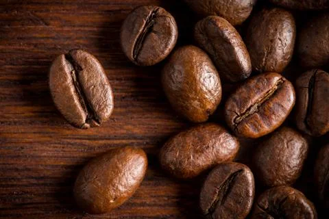 Fresh roasted coffee beans macro close oak wood background Stock Photos