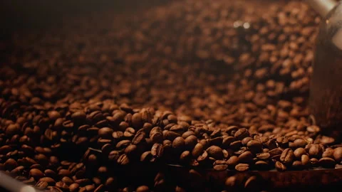 Fresh roasted coffee beans production. Hot coffee beans mixing around on a Stock Footage 267461685