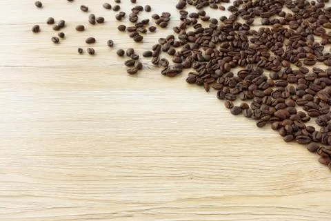 Fresh roasted coffee beans spread out on wooden background Stock Photos