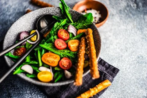 Fresh rocket salad with cherry tomatoes, red onion and bread sticks Stock Photos