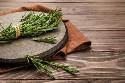 Fresh rosemary sprigs on rustic kitchen table Stock Photos