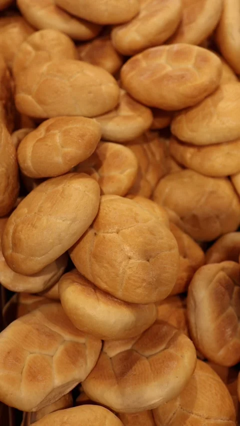 Fresh round bread rolls with golden crust displayed in a bakery section Stock Footage 345356974
