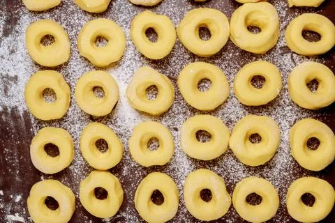 Fresh round donuts on table with flour before frying. Stock Photos