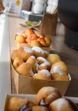 Fresh round small donuts during carnival or fast food festival, glazed with d Stock Photos