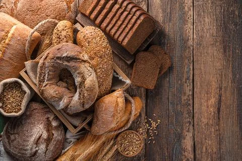 Fresh, rye and wheat bread on a brown, wooden background. Stock Photos