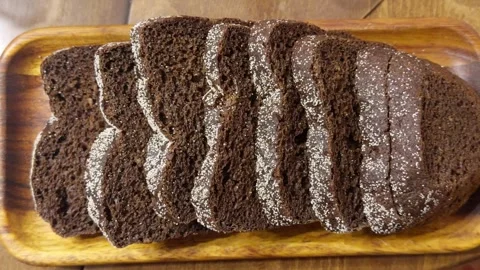 Fresh rye bread with a crispy crust in closeup on a serving board Stock Footage 325183421