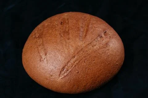 Fresh rye bread or whole grain bread. Isolated object on black background Stock Photos