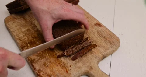 Fresh rye bread sliced for croutons on a cutting board, pieces of fresh soft Stock Footage 318430533