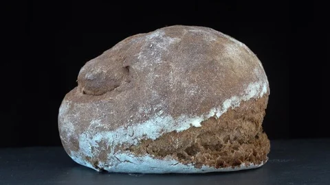 Fresh rye brown bread on black background, close up, rotates, macro Stock Footage 95979629