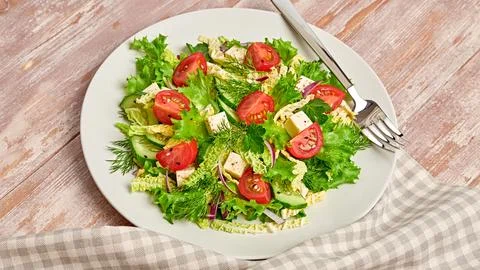 Fresh salad with cherry tomatoes, savoy cabbage, on wood background, minima.. Stock Photos