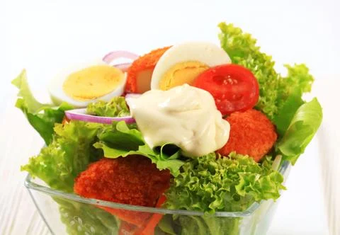 Fresh salad with fried breaded cheese and egg Stock Photos