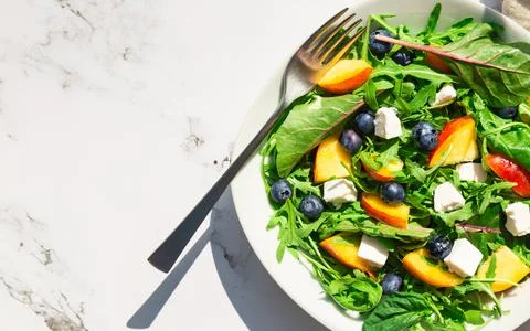 Fresh salad with nectarines, blueberries, arugula, spinach and feta cheese Stock Photos