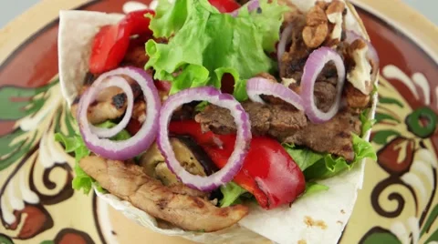 Fresh salad in the pita bread on the painted plate closeup Stock Footage 54998416