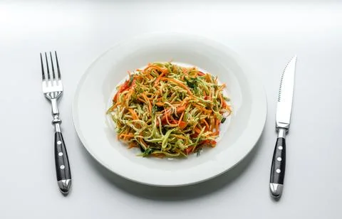 Fresh salad of sliced thin strips of carrot and zucchini on a concrete back.. Stock Photos