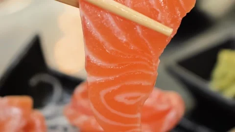 Fresh Salmon Sashimi Slice Held by Wood Chopsticks Closeup Stock Footage 333600266
