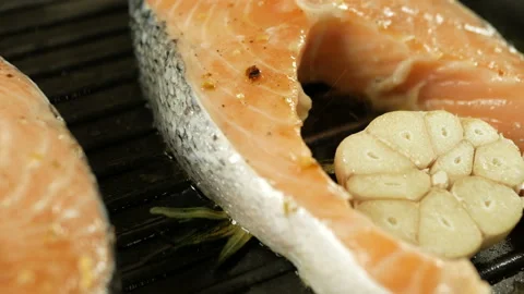 Fresh salmon steaks with grill marks cooking for a healthy meal, close-up Stock Footage 97799486