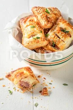 Fresh sausage in puff pastry with thyme and sesame seeds Stock Photos