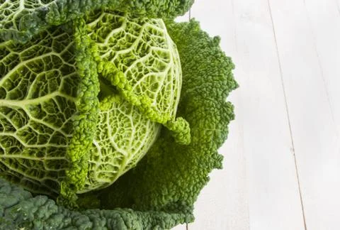 Fresh savoy cabbage closeup on rustic wooden background Stock Photos