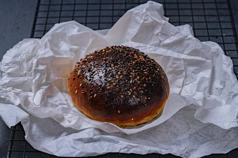 Fresh Seeded Burger Bun on Rustic Baking Paper Stock Photos
