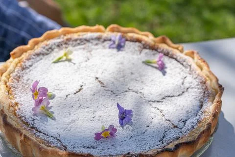 Fresh self made easter pie on table with flower decoration into garden. Stock Photos